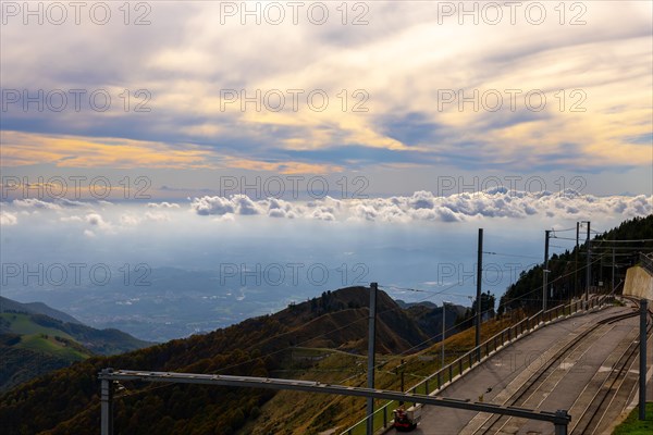 Railroad Station with Railroad Tracks with Mountainscape and Beautiful Clouds in a Sunny Day in Monte Generoso