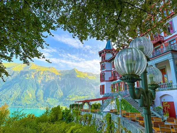 Grandhotel Giessbach with Terrace and Street Lamp and Mountain with Lake Brienz in a Sunny Summer Day in Brienz