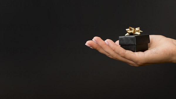 Black gift box with golden ribbons