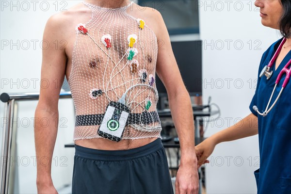 Cardiologist attaching a Ecg Holter to a patient to perform a cardiovascular stress test in the hospital