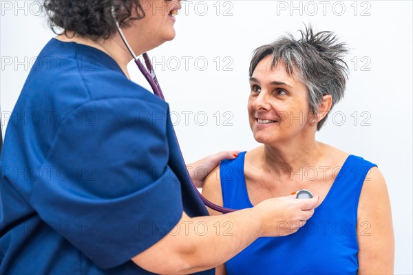Cardiologist listening to the heartbeats of an older woman