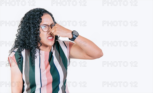 Afro woman covering her nose from a bad smell isolated. Displeased person holding her nose isolated. Disgust girl covering nose