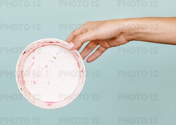 Close up hand holding dirty plate
