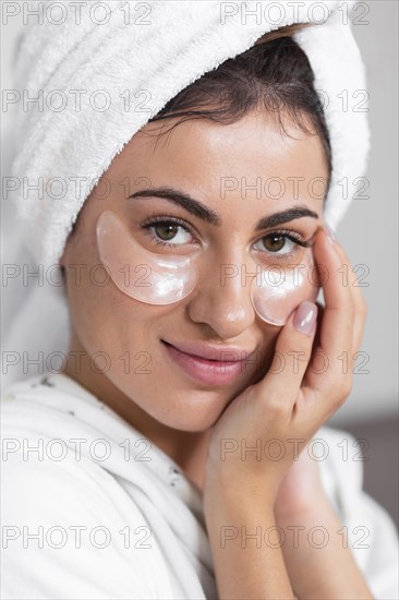 Front view beautiful smiley woman using eye patches