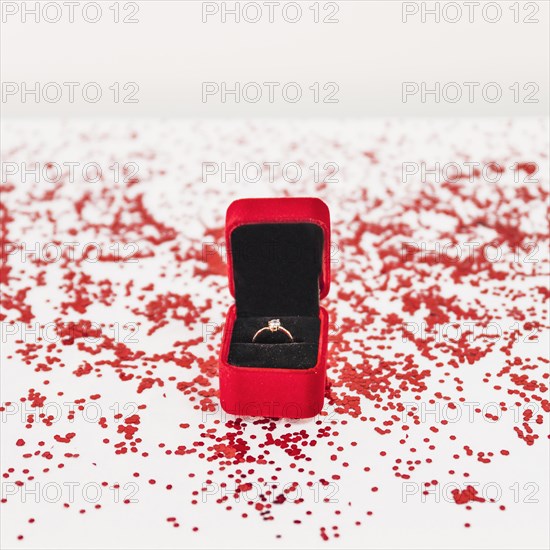 Jewellery box with ring near confetti