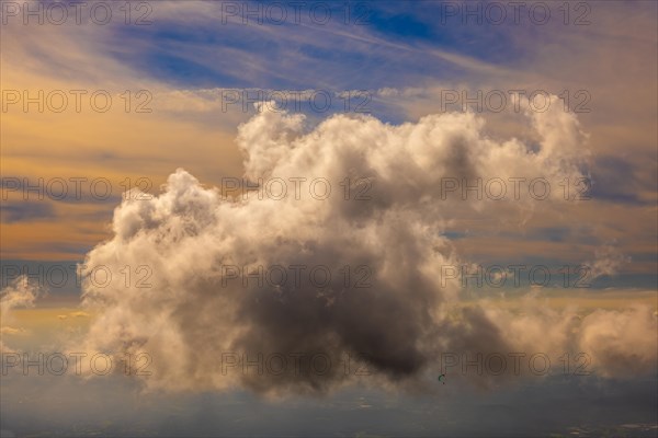 Aerial View over a Beautiful Floating Storm Cloud and a Paraglider Flying with Sunlight in Ticino