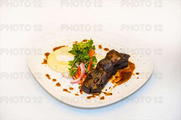 Delicious and luxury dish of Short Ribs of Beef on a white table