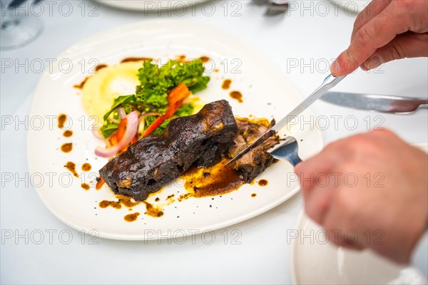 Top view of a man eating meat in a luxury restaurant