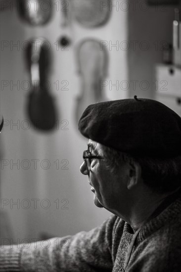 Portrait of senior violinmaker in workshop in Cremona