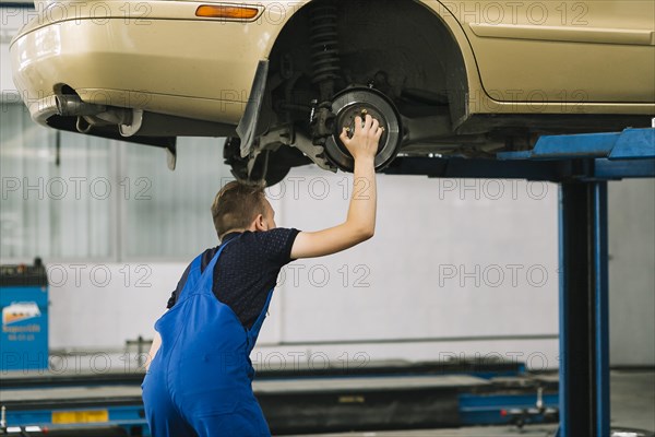 Auto mechanic holding hob car