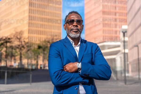 Portrait of a proud african businessman standing with arms crossed outdoors