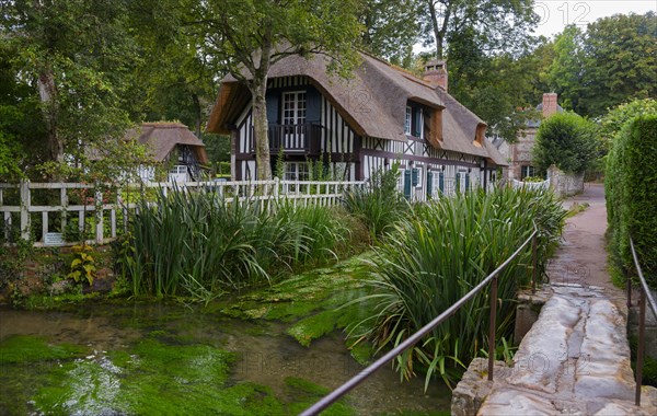 Half-timbered house with thatched roof on the river Veules