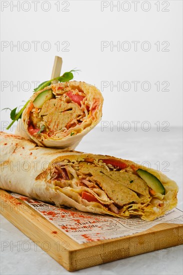 Rolled pita with falafel and vegetables cut on half