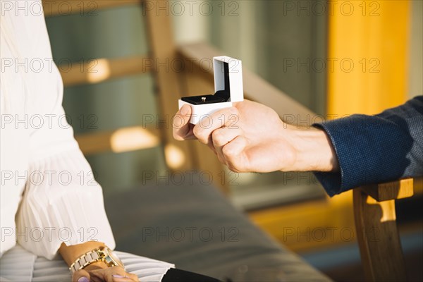 Man s hand showing engagement ring box her girlfriend