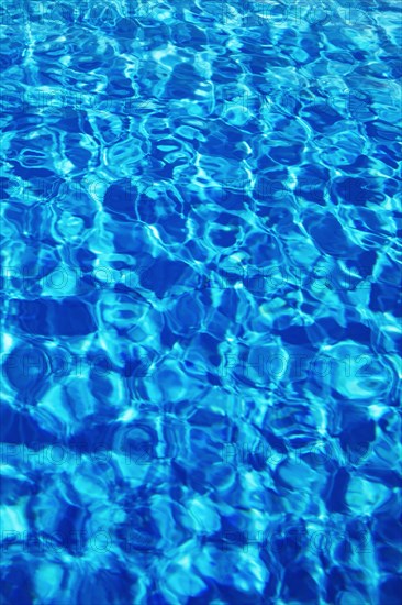 Water surface with light reflections in a swimming pool