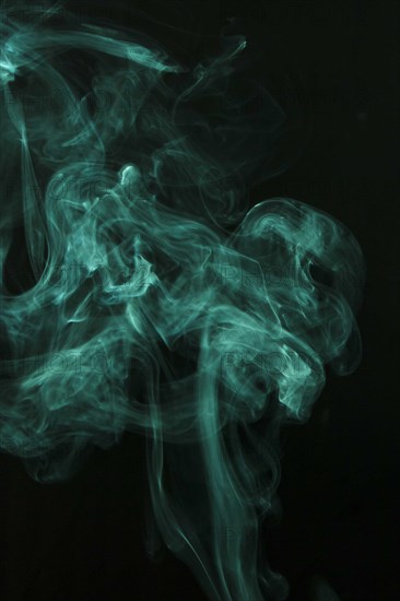 Wispy green smoke spread black background