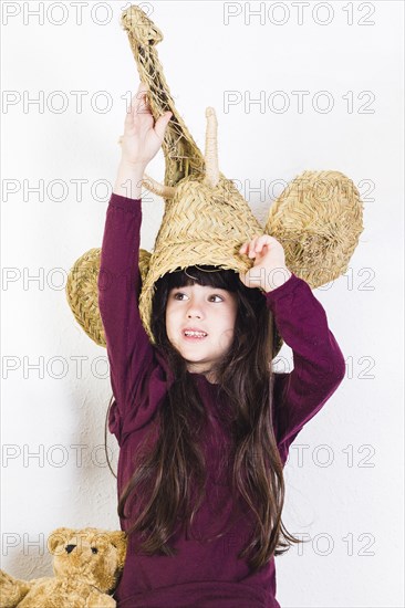 Girl with wicker elephant mask her head