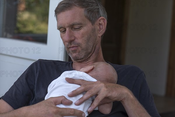 Young grandfather with his newborn grandson