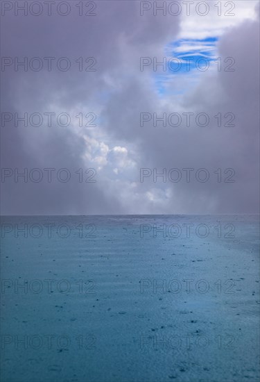 Rippled water surface during rain in swimming pool with dramatic cloudy sky