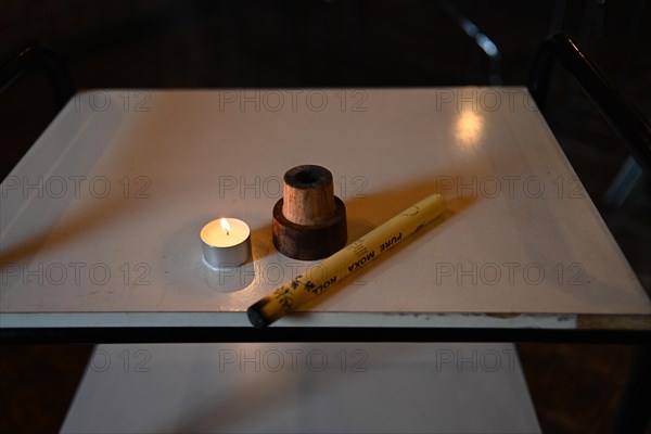 Burning mugwort or moxa herb and candle to facilitate healing blood flow in naturopathy clinic