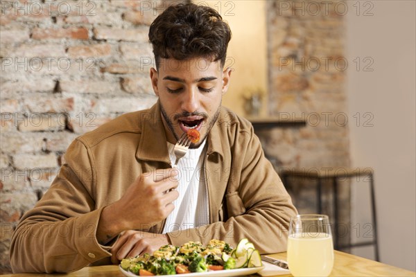 Medium shot man eating indoors