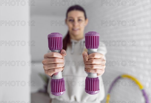 Medium shot woman holding dumbbells 2