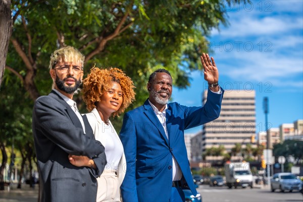 Multi-ethnic business people waiting for a taxi and gesturing to call one