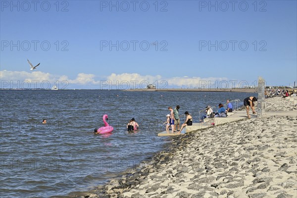 Concreted seashore with bathers