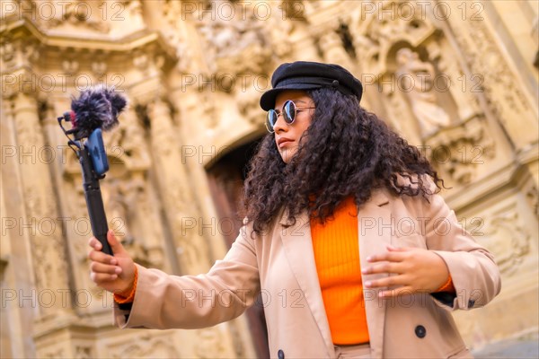 Blogger creating content with mobile visiting a a ancient monument in the city in winter