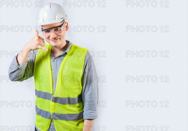 Handsome engineer making call gesture with fingers. Portrait of young engineer making call gesture isolated