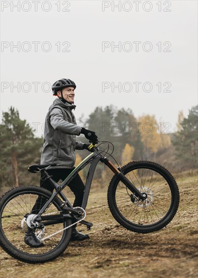 Front view man riding bike mountain