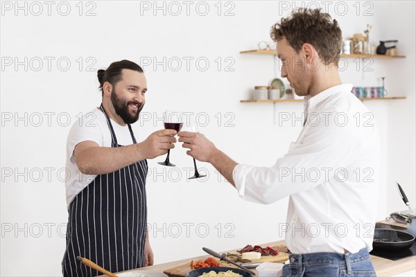 Medium shot men clinking glasses