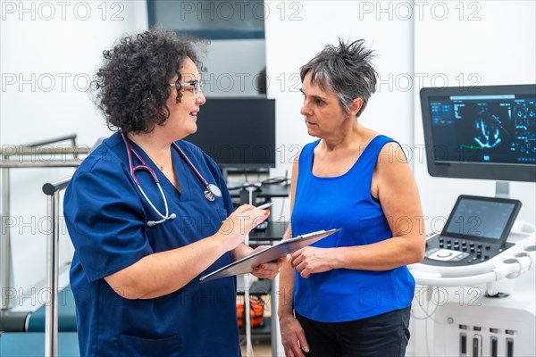 Cardiologist talking to a patient after an echocardiogram in an hospital