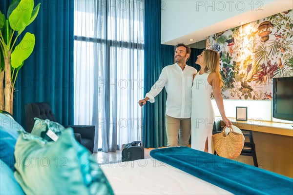 Couple with luggage and handbag contemplating an hotel room as they arrived