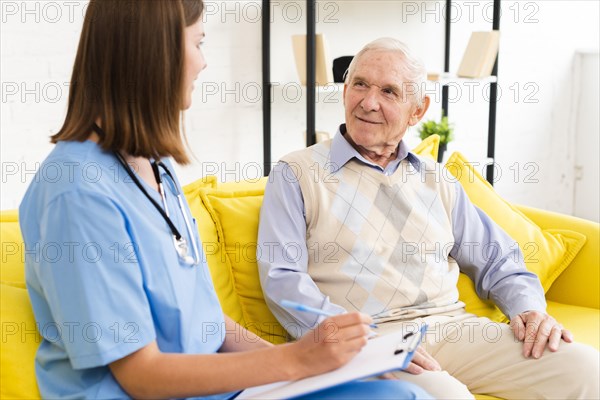 Medium shot caregiver talking old man