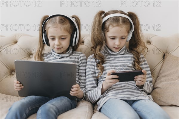 Cute twins using digital devices