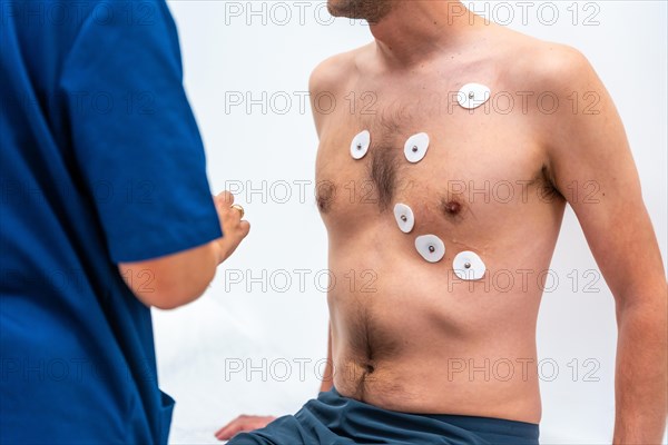 Doctor cardiologist placing the electrodes to perform an echocardiogram to a patient in the hospital