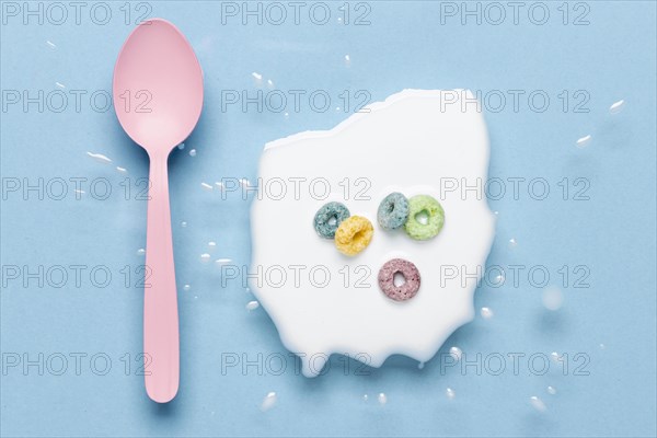 Flat lay pink spoon splash milk with cereals