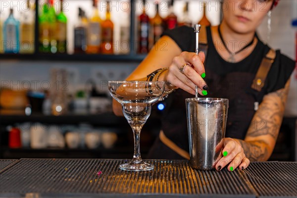 Professional bartender preparing a cocktail in the counter of a bar