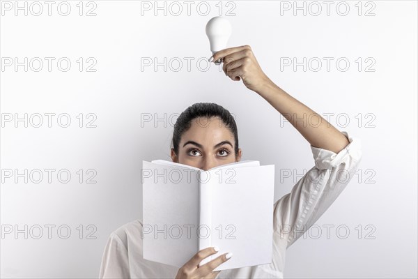 Front view woman holding light bulb book