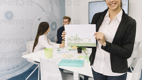 Happy businesswoman showing energy saving concept paper