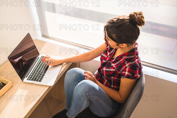 Top view of a young freelancer working from home using laptop