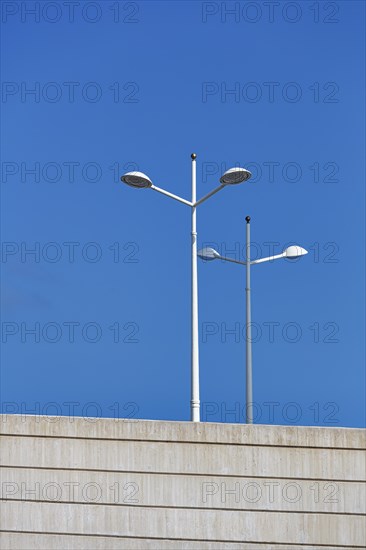 White street lamps against a blue sky