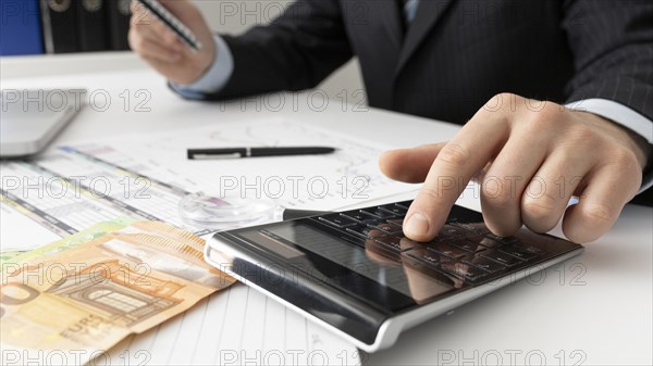 Business man calculating finance numbers close up