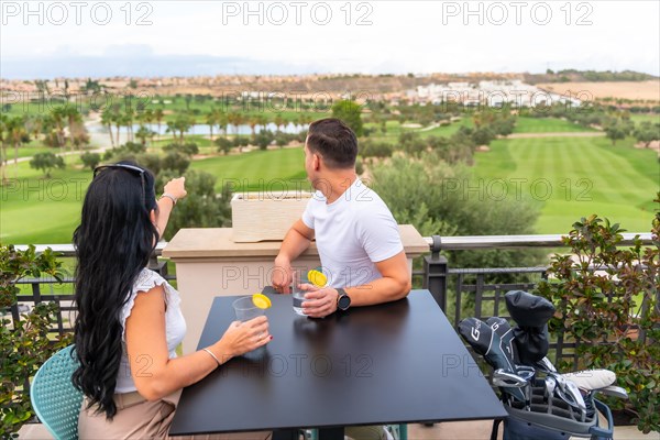 Couple enjoying of a cocktail on the terrace of a golf club