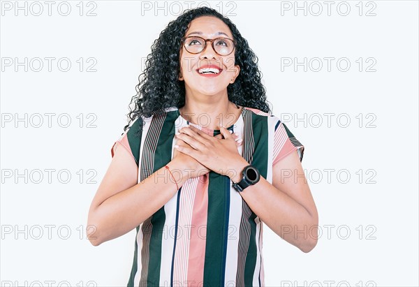 Grateful relaxed afro girl with hands on chest. Concept of grateful people. Positive afro woman with a charming sincere smile feeling grateful