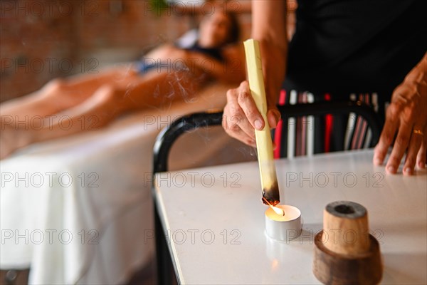 Therapist burning mugwort or moxa herb to facilitate healing blood flow in naturopathy clinic