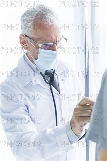 Doctor mask examining crop patient