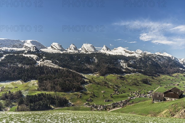 View of the snow-covered Churfirsten and the village of Alt St Johann