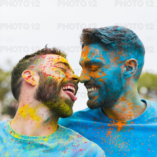 Gay having fun kissing holi festival